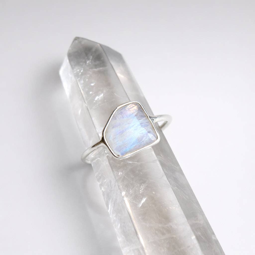 Silver ring with a rainbow moonstone on a clear crystal background