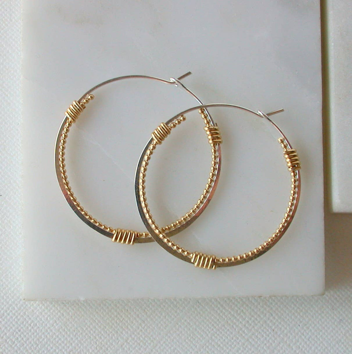Gold and silver hoop earrings on a white background
