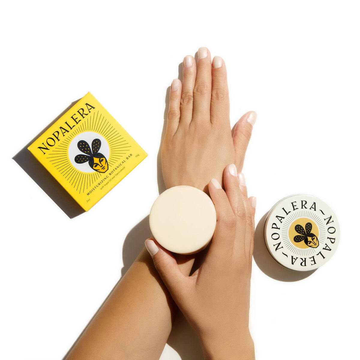 Nopalera skincare product with hands holding a container on a white background