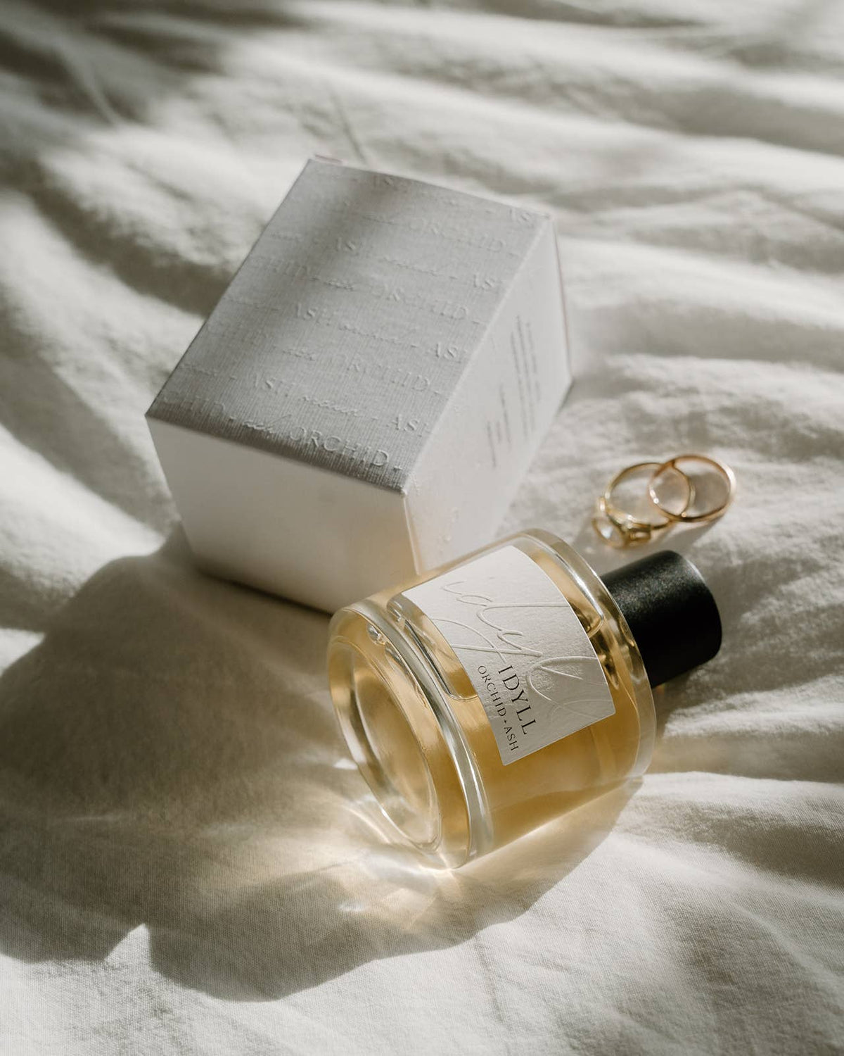 Perfume bottle and packaging on a textured surface