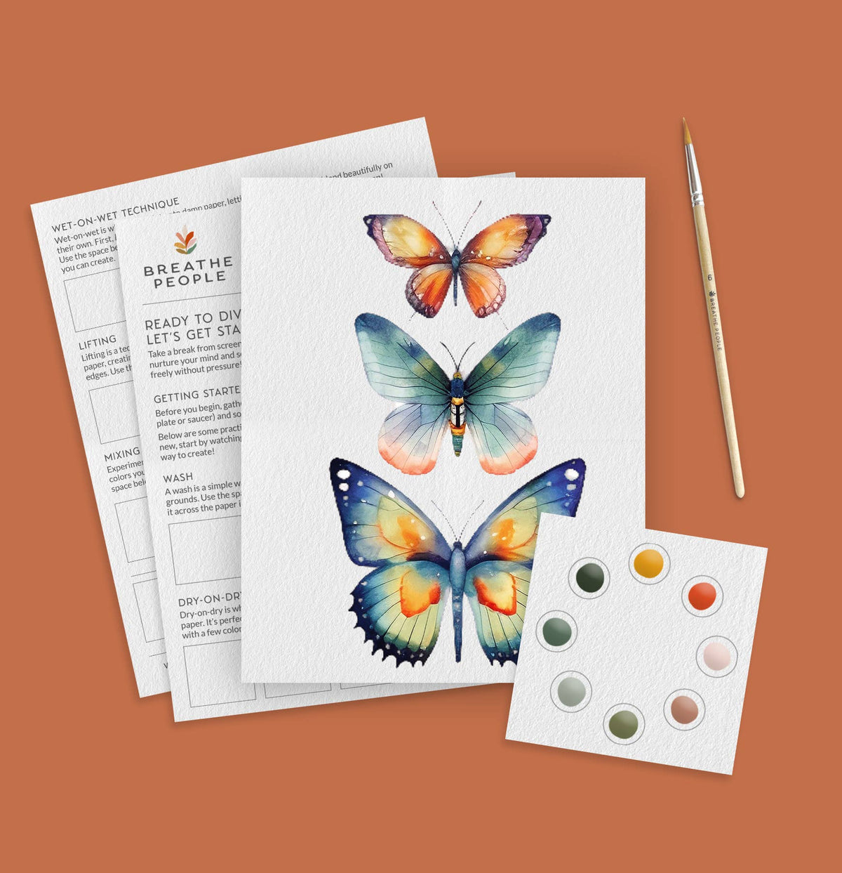 Paint kit of butterfly illustration sheet with paint swatches and a brush on a brown background