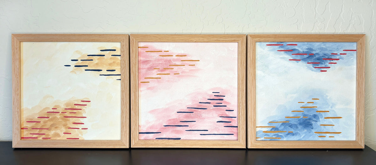 Three framed paintings that are abstract interpretations of Arizona's desert atmosphere.