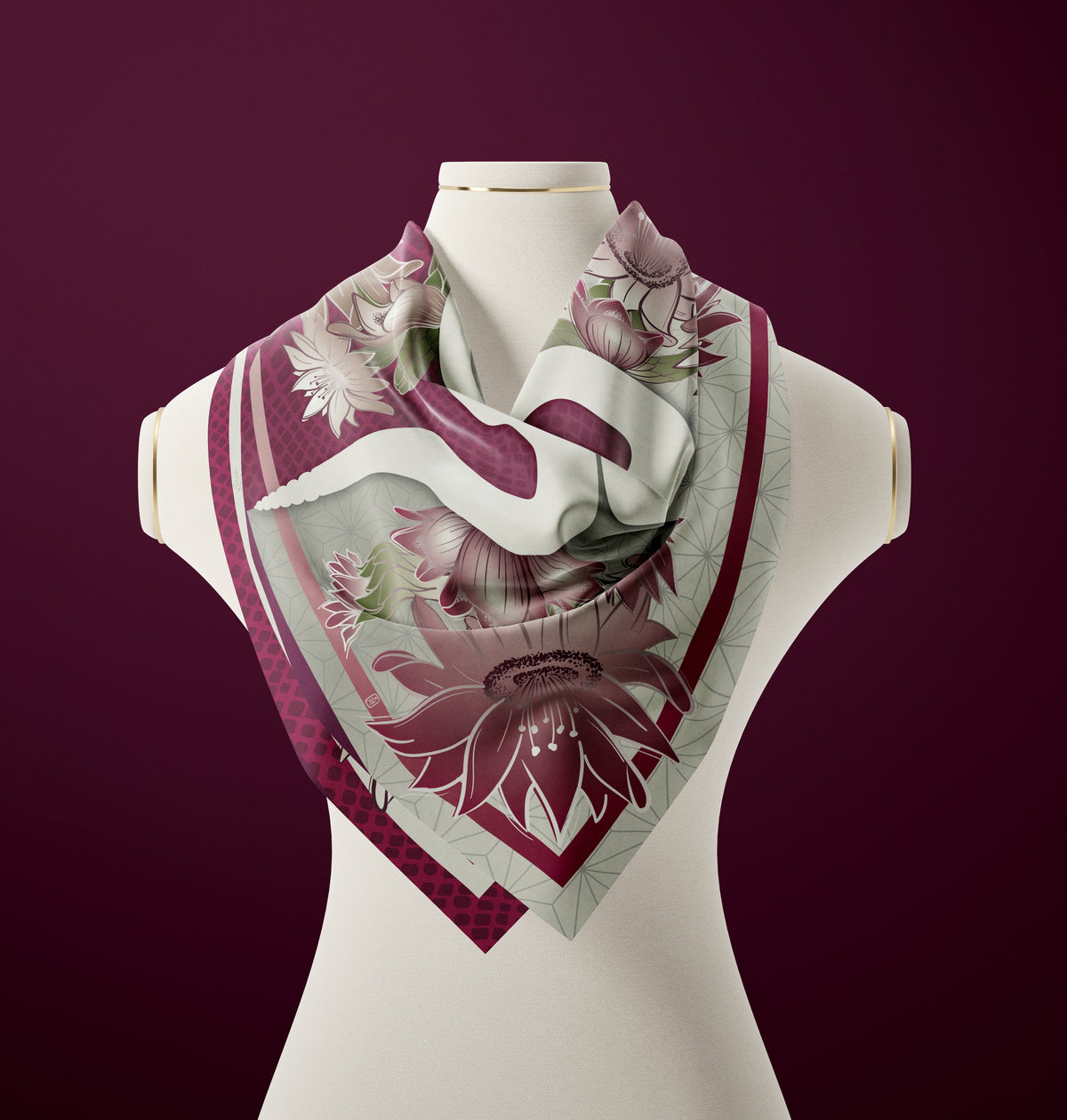 A silk scarf with a floral pattern in shades of pink, green, and gray displayed on a mannequin.