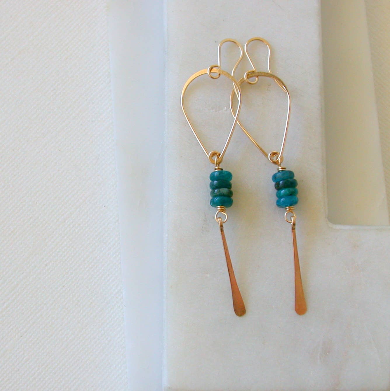 Gold and apatite beaded earrings on a white background