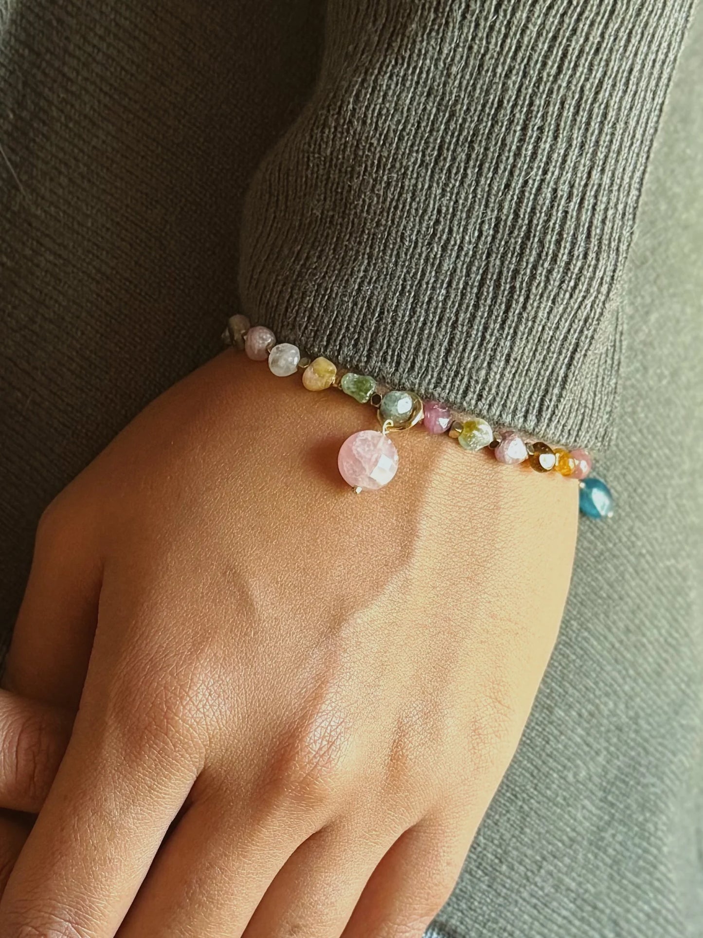 Multicolored beaded bracelet on a wrist with a neutral background