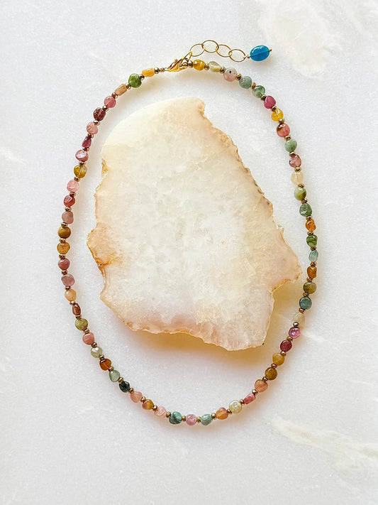Necklace with multicolored gemstone beads on a white stone surface