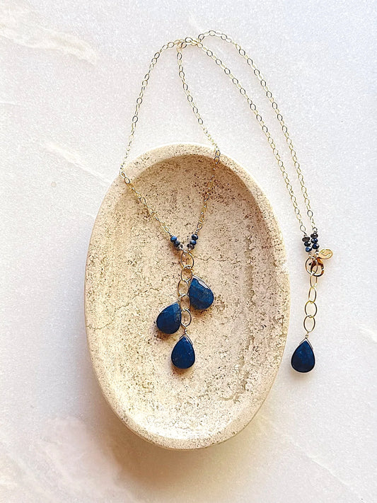 Necklace with blue teardrop lapis pendants on a white surface