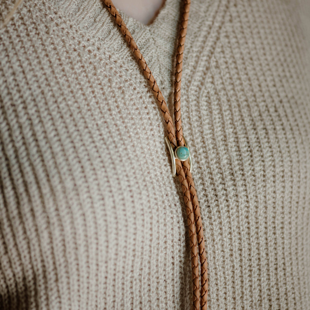 brown and pear bolo tie close up on sweater
